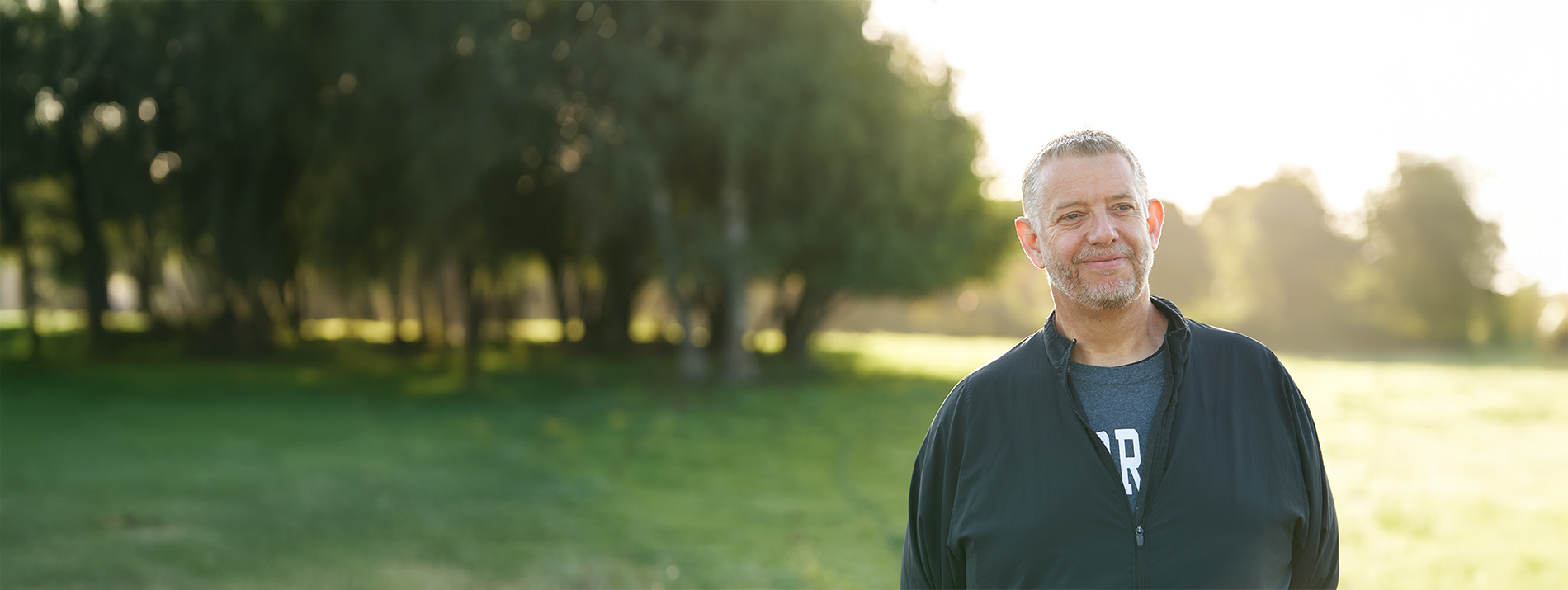 Three women walking together outdoors on a sunny day, enjoying each other’s company.